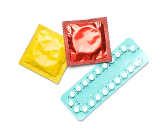 Photo of Condoms and birth control pills on white background, top view. Safe sex concept