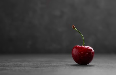 Photo of Delicious fresh sweet cherry with water drops on dark grey background