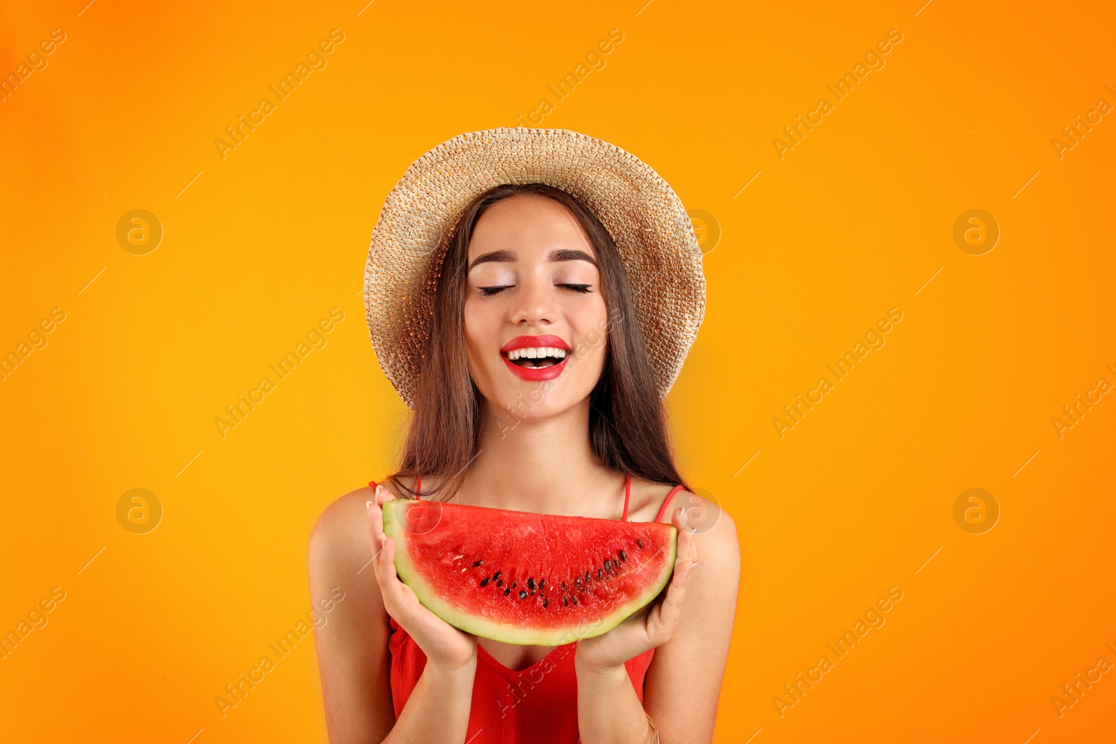 Photo of Beautiful young woman posing with watermelon on color background