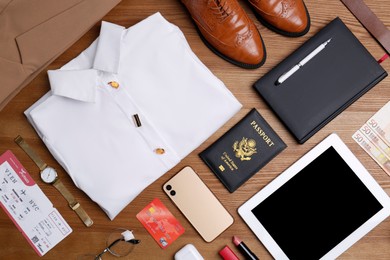 Business trip stuff on wooden surface, flat lay