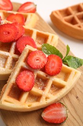 Photo of Tasty Belgian waffles with strawberries and mint on table, closeup