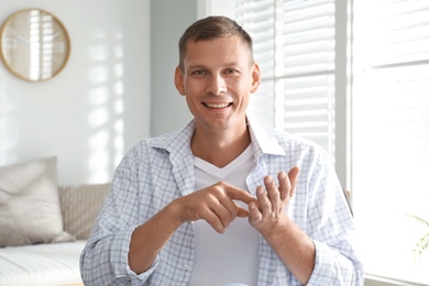 Man talking to his coworkers through video conference indoors, view from webcam