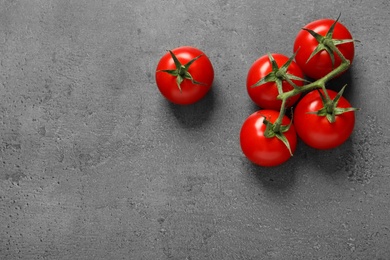 Fresh cherry tomatoes on stone background, flat lay. Space for text