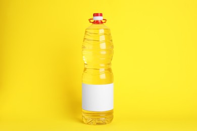 Bottle of cooking oil on yellow background