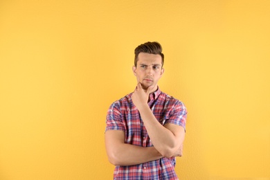 Photo of Thoughtful handsome young man on color background