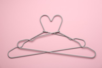 Photo of Two hangers on pink background, top view
