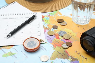 Photo of Different travel accessories on world map. Planning summer vacation trip
