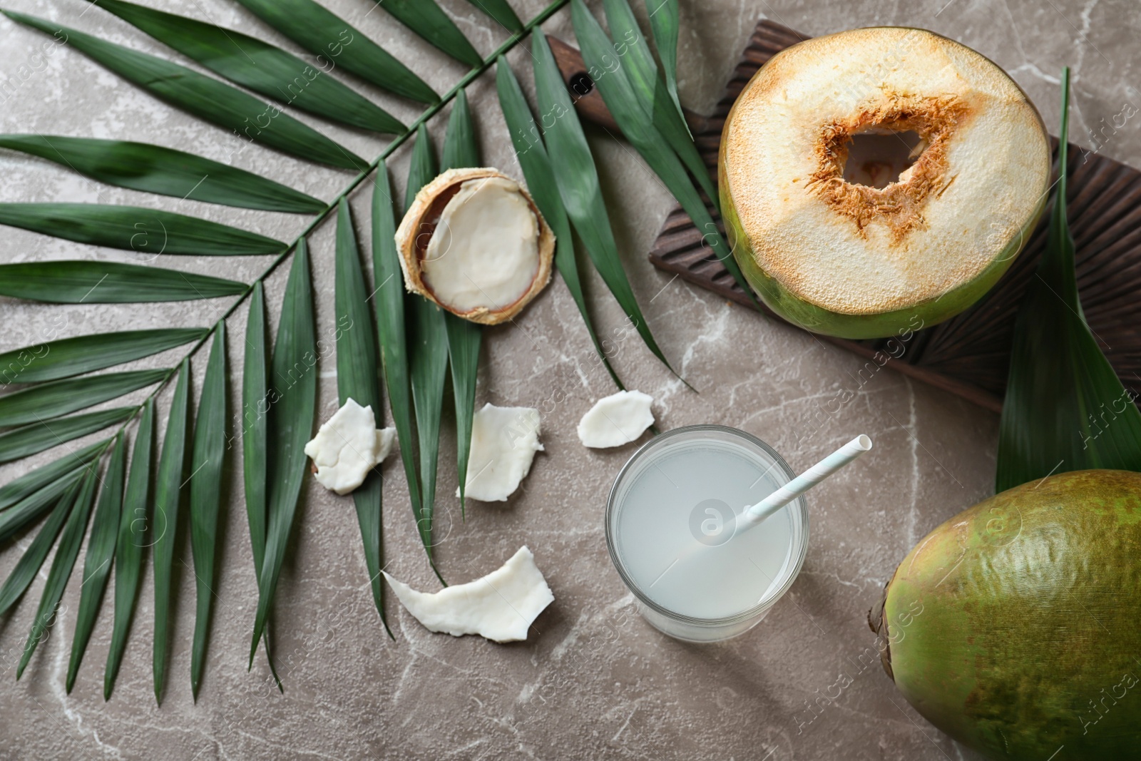 Photo of Beautiful composition with fresh green coconuts and glass of milk on table, top view