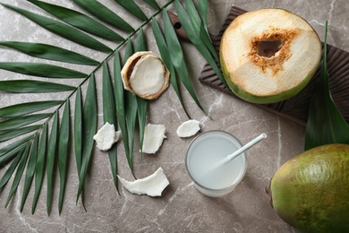 Beautiful composition with fresh green coconuts and glass of milk on table, top view