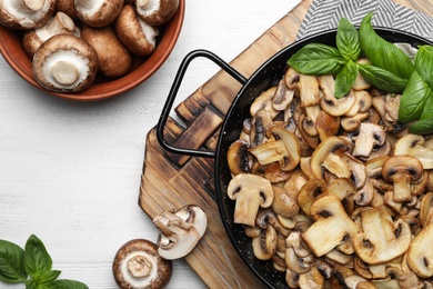 Photo of Flat lay composition with delicious cooked mushrooms on table
