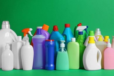 Photo of Many different cleaning supplies on green background