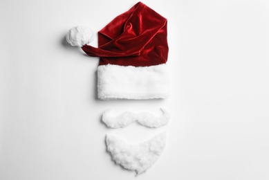 Photo of Santa Claus hat with beard on white background, top view