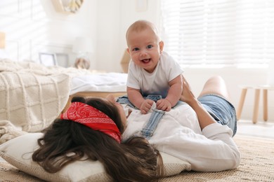 Young mother with her cute baby on floor at home