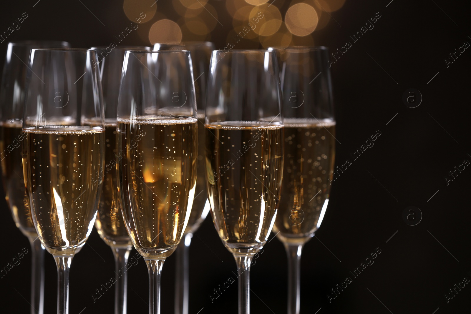 Photo of Glasses of champagne on blurred background, closeup. Space for text