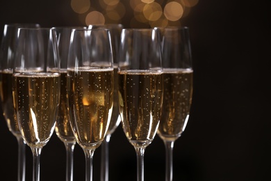 Glasses of champagne on blurred background, closeup. Space for text