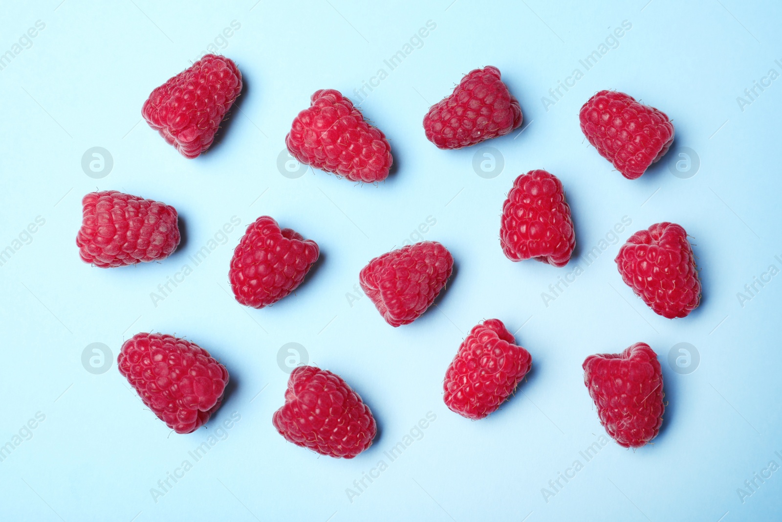 Photo of Flat lay composition with delicious ripe raspberries on blue background