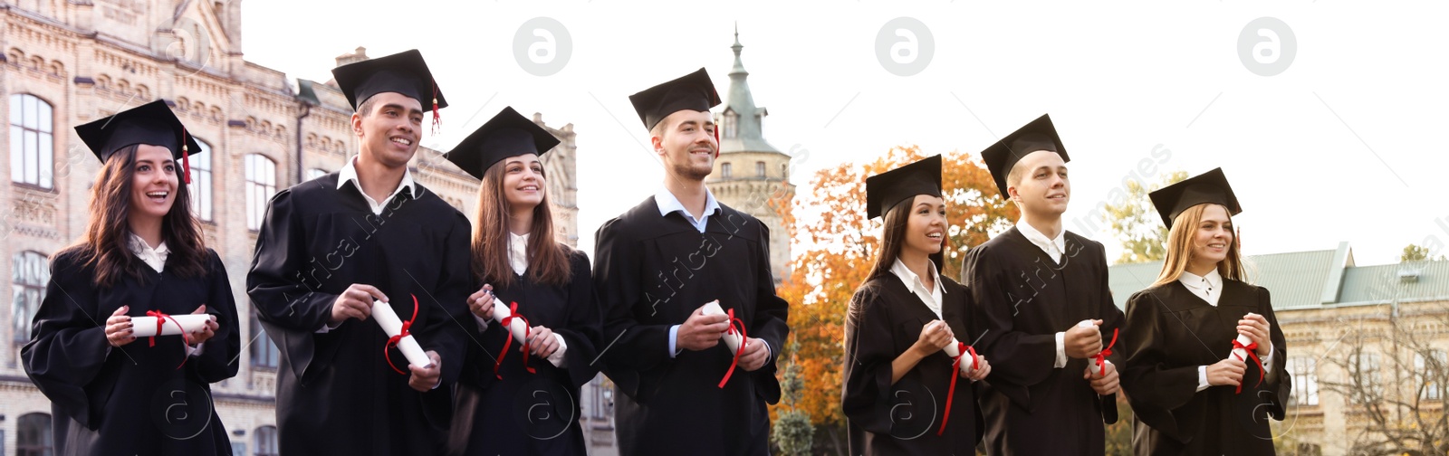 Image of Happy students with diplomas near campus. Banner design