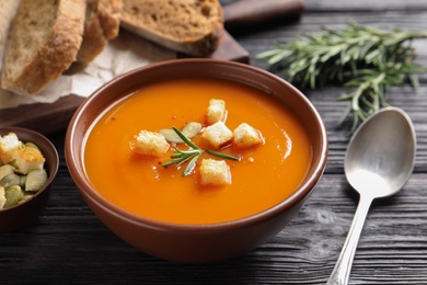 Photo of Bowl of tasty sweet potato soup served on table