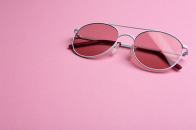 Photo of Stylish sunglasses on pink background, space for text. Fashionable accessory