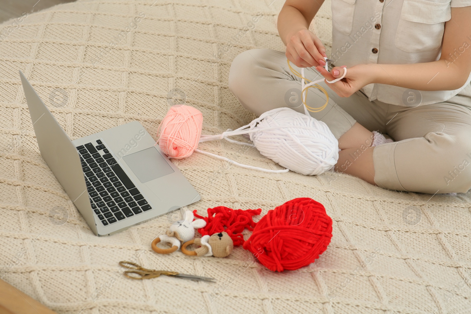 Photo of Woman learning to knit with online course at home, closeup. Handicraft hobby