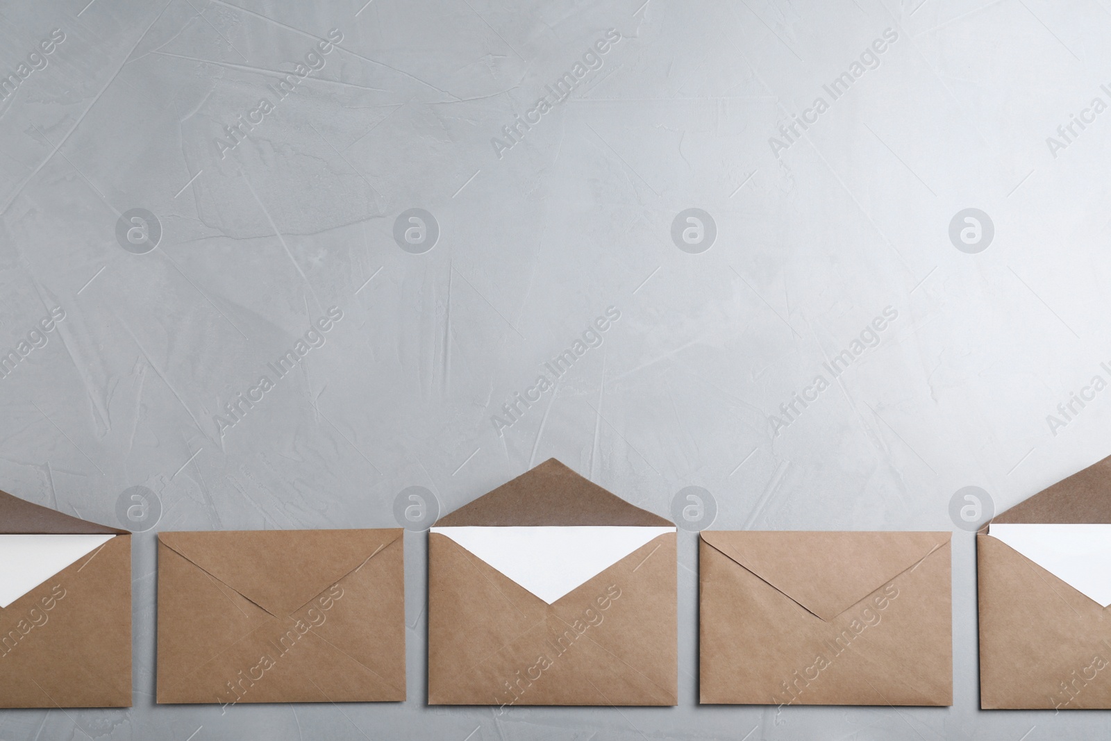 Photo of Many brown paper envelopes on light grey table, flat lay. Space for text
