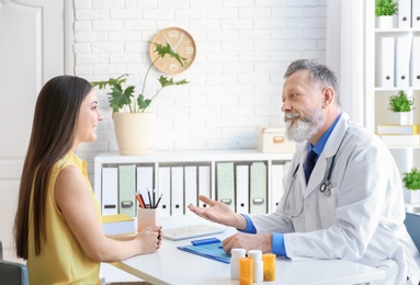 Photo of Mature doctor consulting patient in clinic