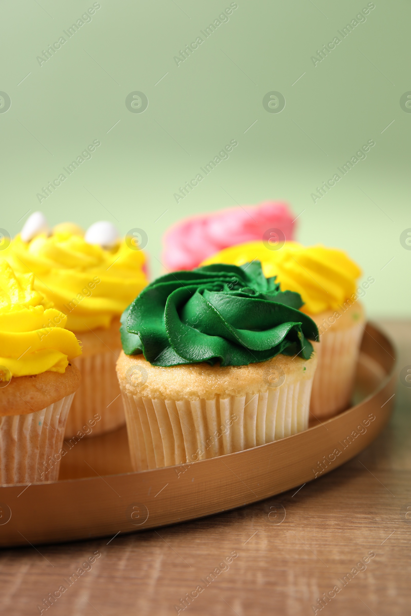 Photo of Delicious cupcakes with bright cream on wooden table, closeup