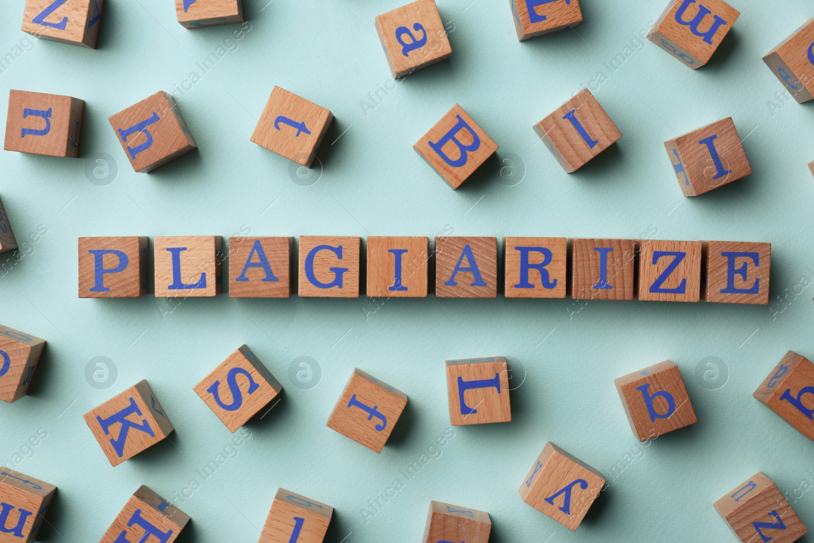 Photo of Wooden cubes with word Plagiarize on turquoise background, flat lay