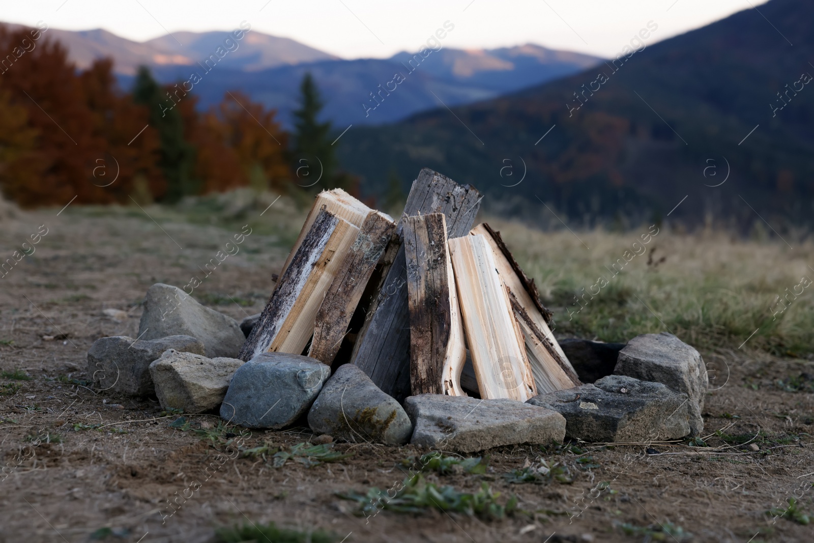 Photo of Bonfire with dry wood and stones in mountains