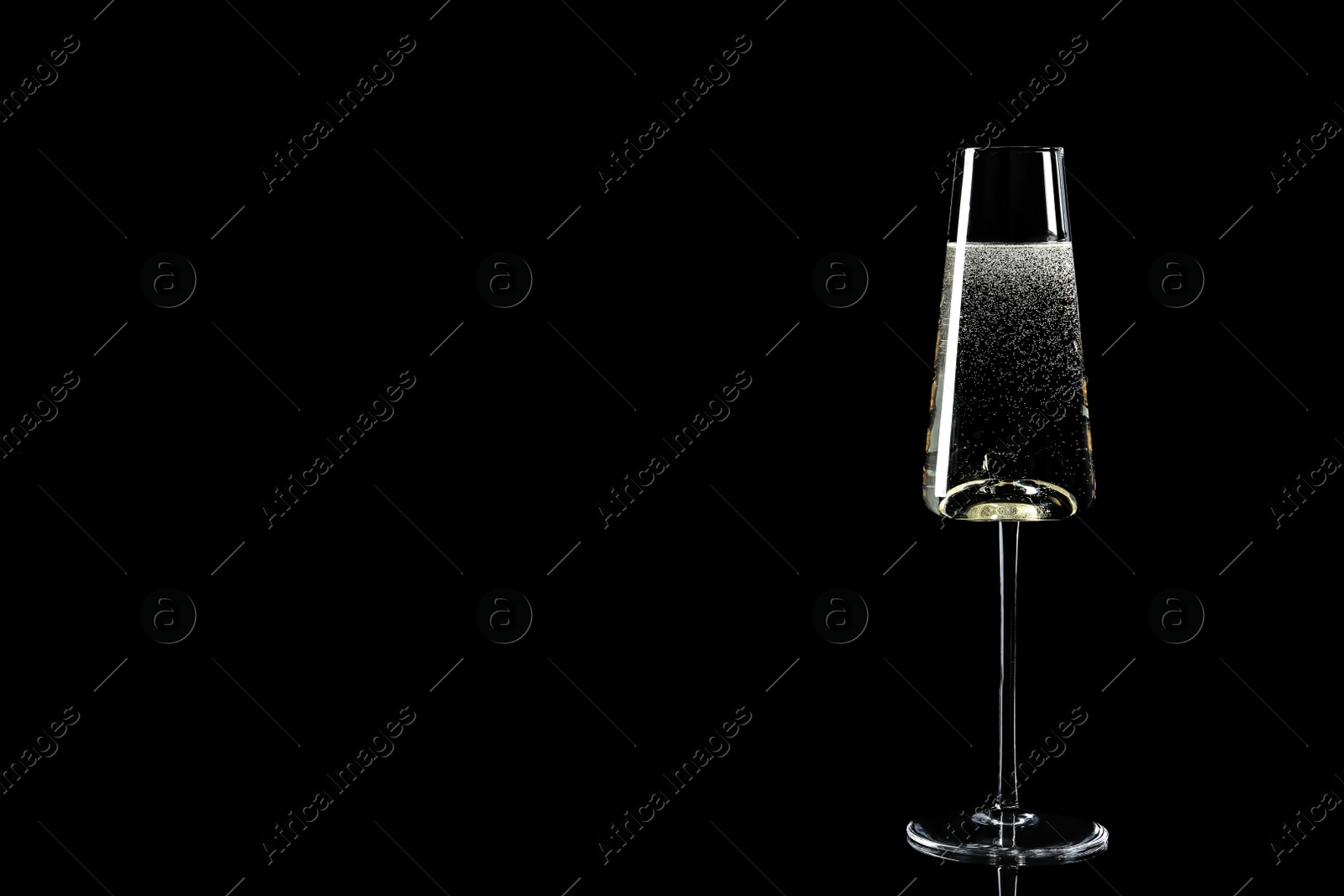 Photo of Glass of champagne on black background, space for text