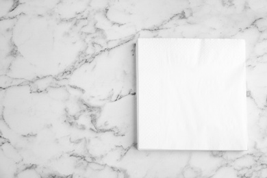 Photo of Stack of clean paper tissues on white marble table, top view. Space for text