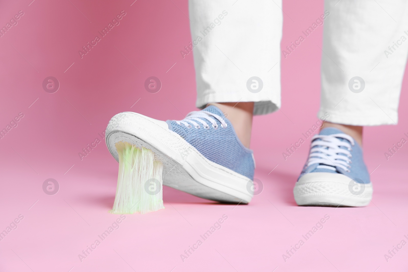 Photo of Person stepping into chewing gum on pink background, closeup