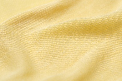 Photo of Texture of bright yellow crumpled fabric as background, closeup