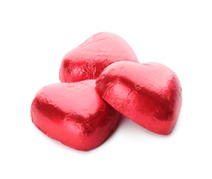 Photo of Heart shaped chocolate candies in red foil on white background