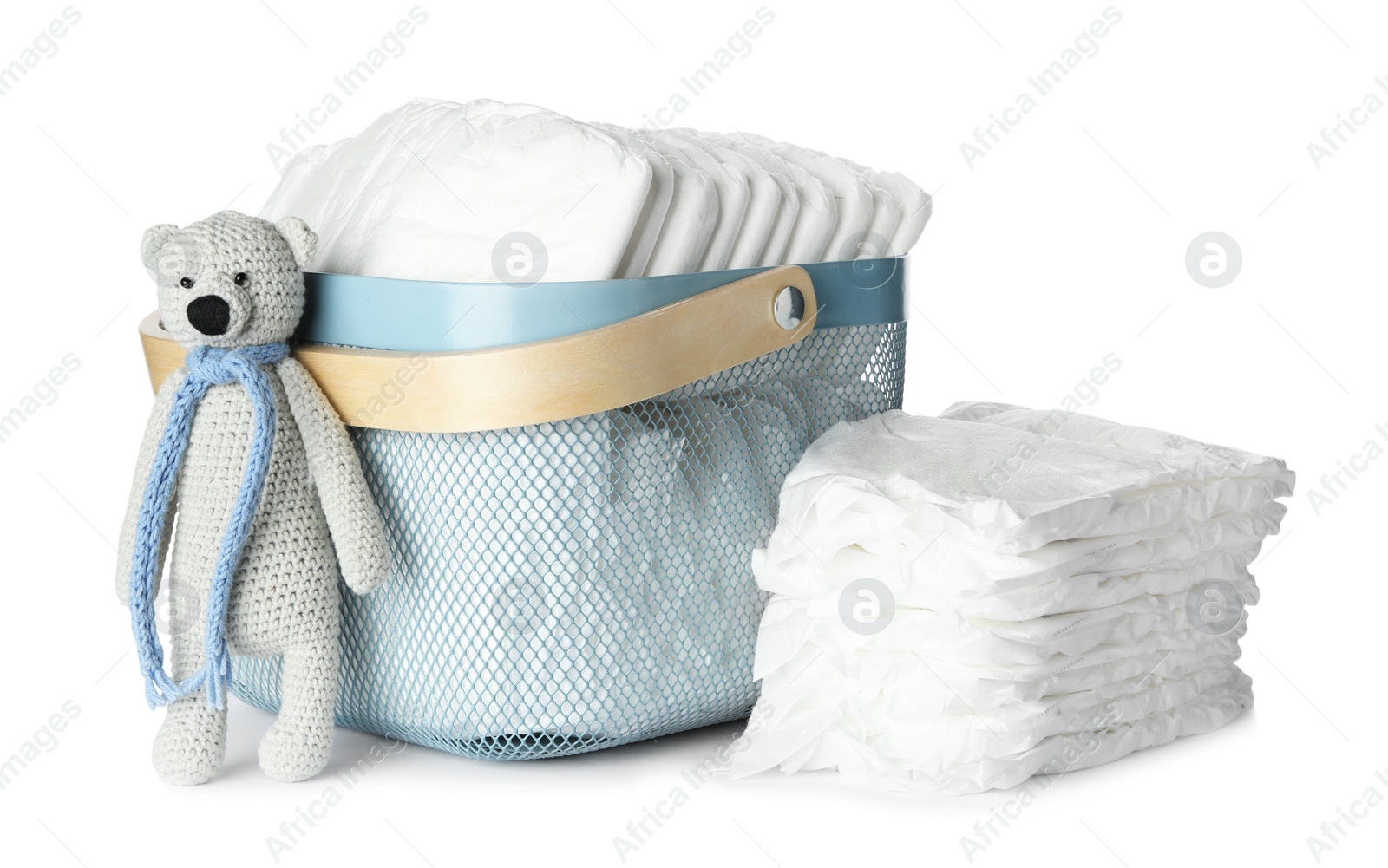 Photo of Disposable diapers and toy bear on white background