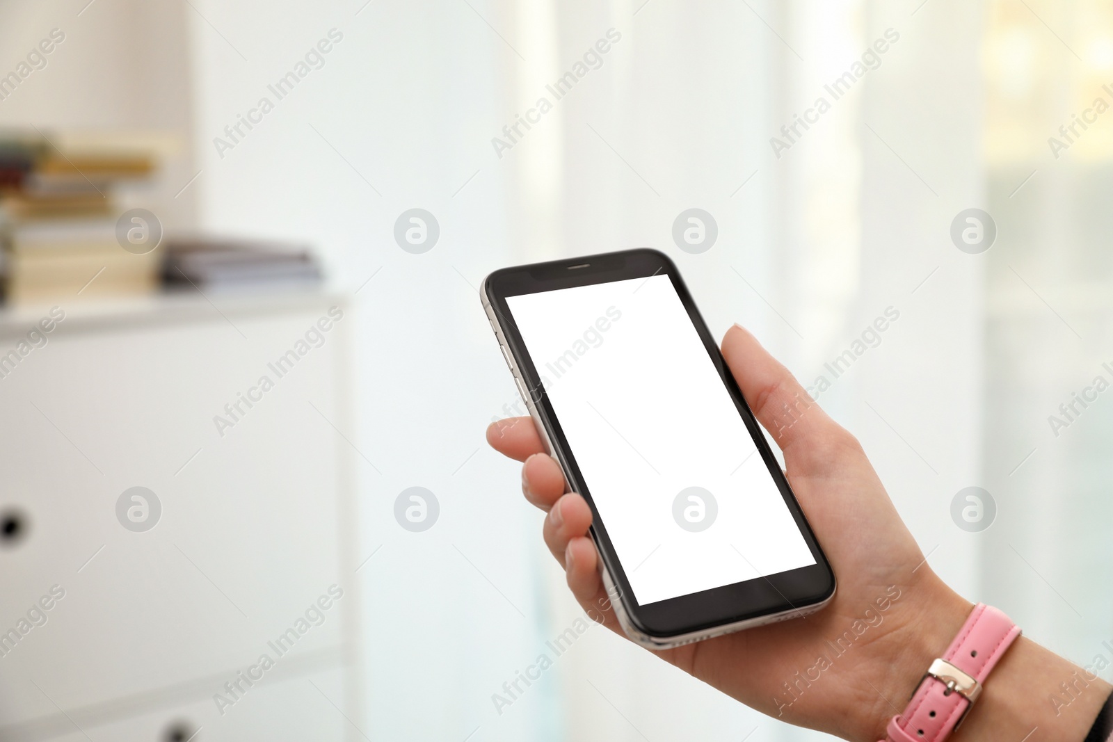 Photo of Woman holding smartphone with blank screen indoors, closeup of hand. Space for text