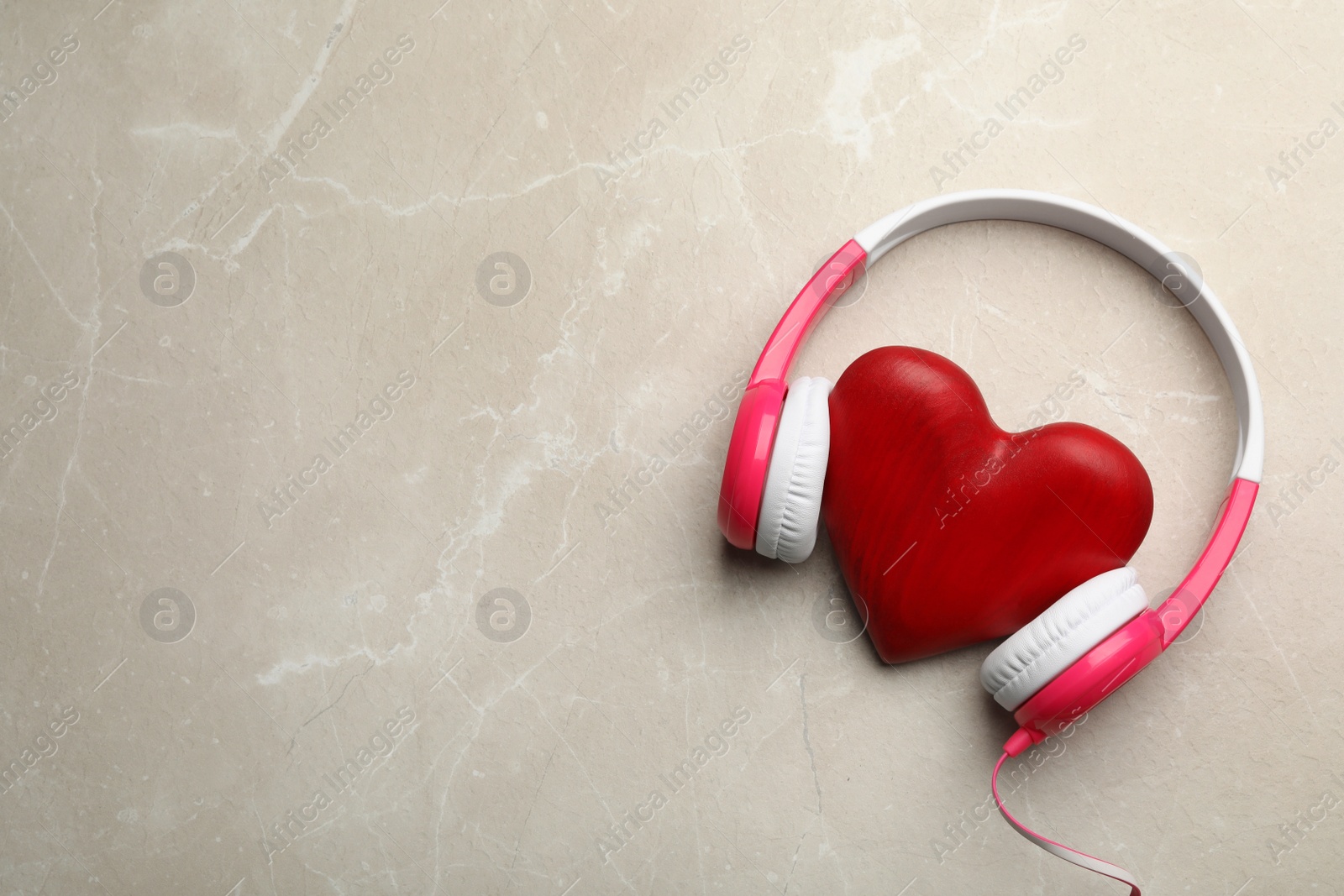 Photo of Decorative heart with modern headphones on table, top view. Space for text