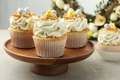 Photo of Tasty Easter cupcakes with vanilla cream on gray table