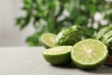 Photo of Fresh ripe bergamot fruits on light grey table against blurred background, space for text