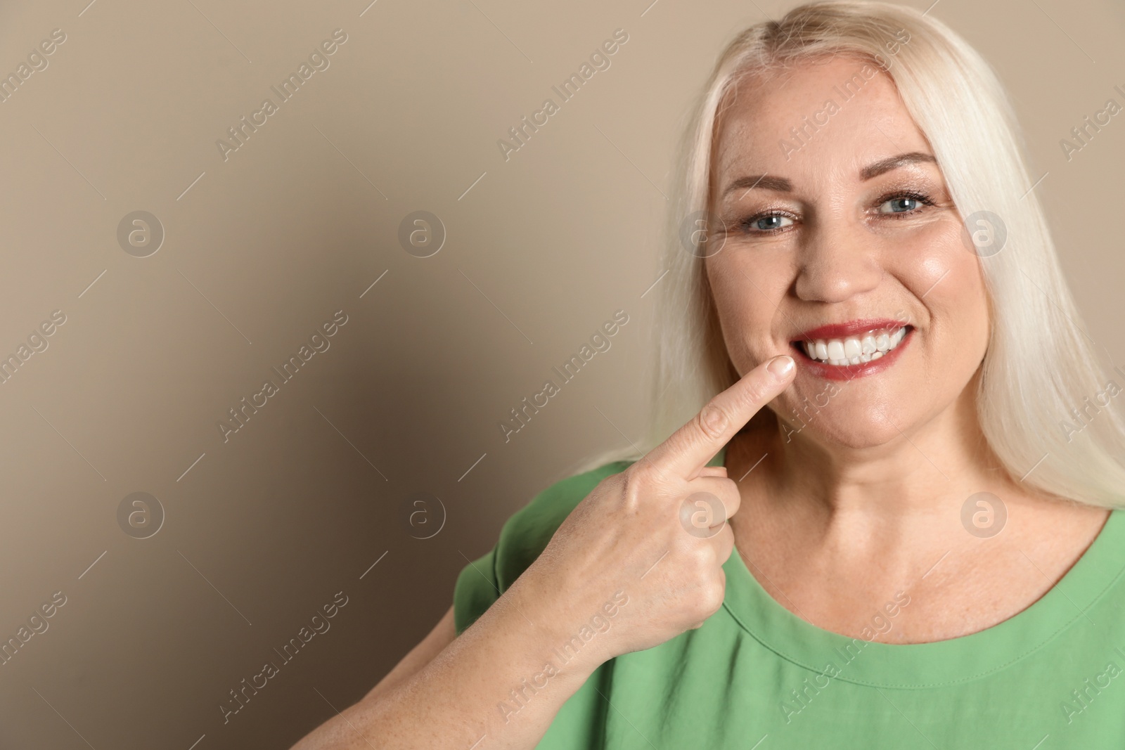 Photo of Smiling woman with perfect teeth on color background. Space for text