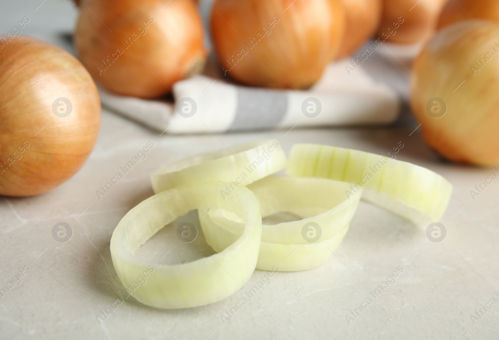 Photo of Rings of fresh onion and bulbs on grey table