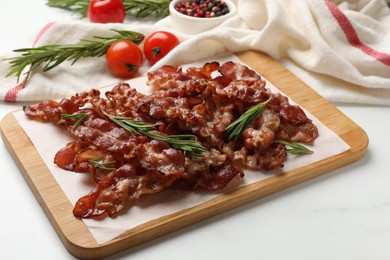 Photo of Slices of tasty fried bacon with rosemary on white table