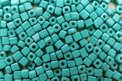 Photo of Bright turquoise beads as background, top view
