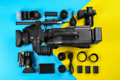 Photo of Flat lay composition with video camera and other equipment on color background