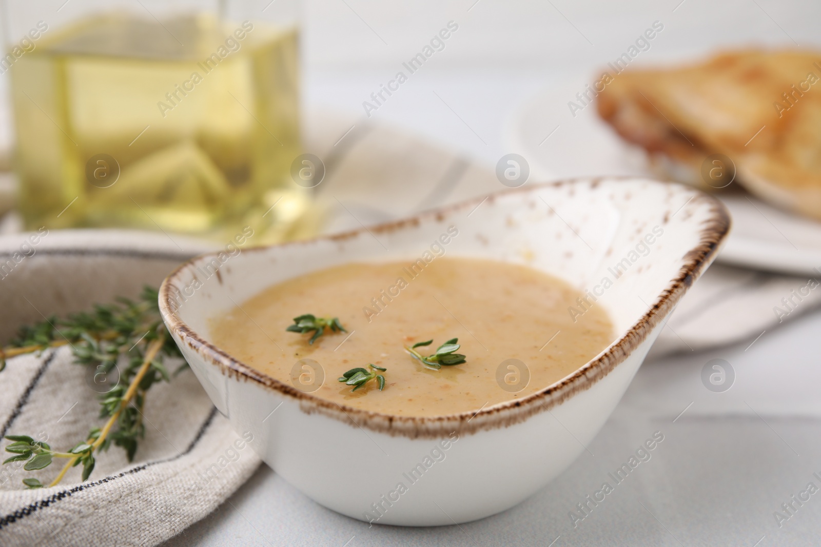 Photo of Delicious turkey gravy and thyme on white table, closeup