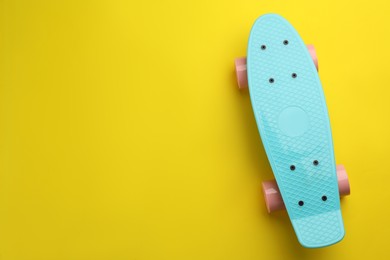 Skateboard on yellow background, top view. Space for text