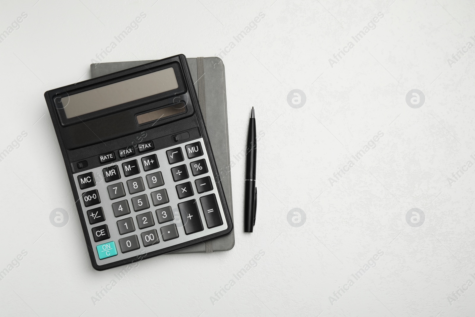 Photo of Calculator and office stationery on white table, top view. Space for text