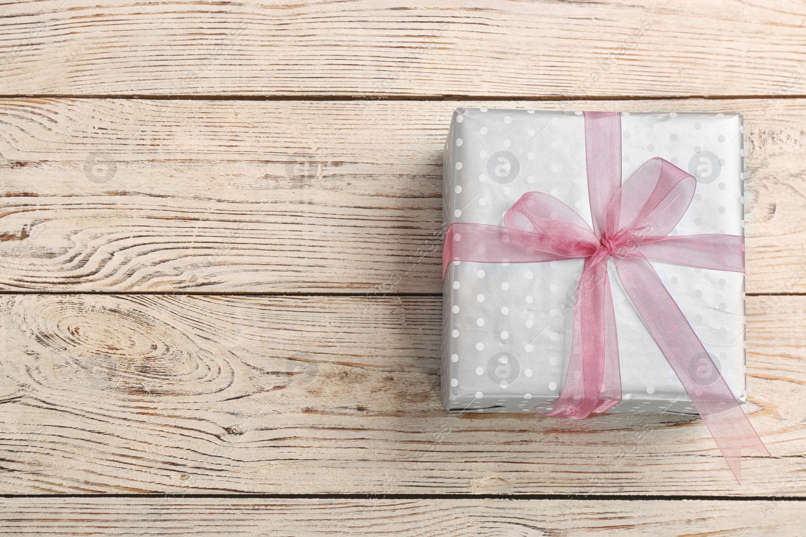 Photo of Elegant gift box with bow on wooden background, top view