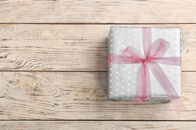 Photo of Elegant gift box with bow on wooden background, top view