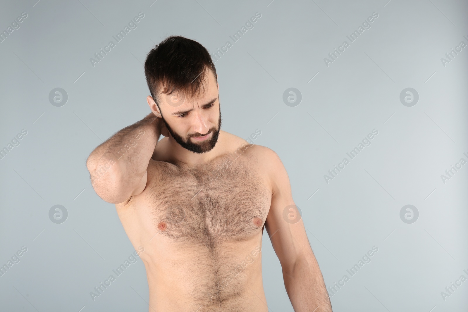 Photo of Young man suffering from neck pain on light background